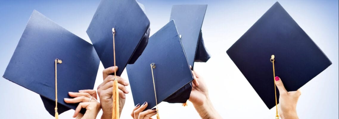 A group of people holding up their graduation caps.