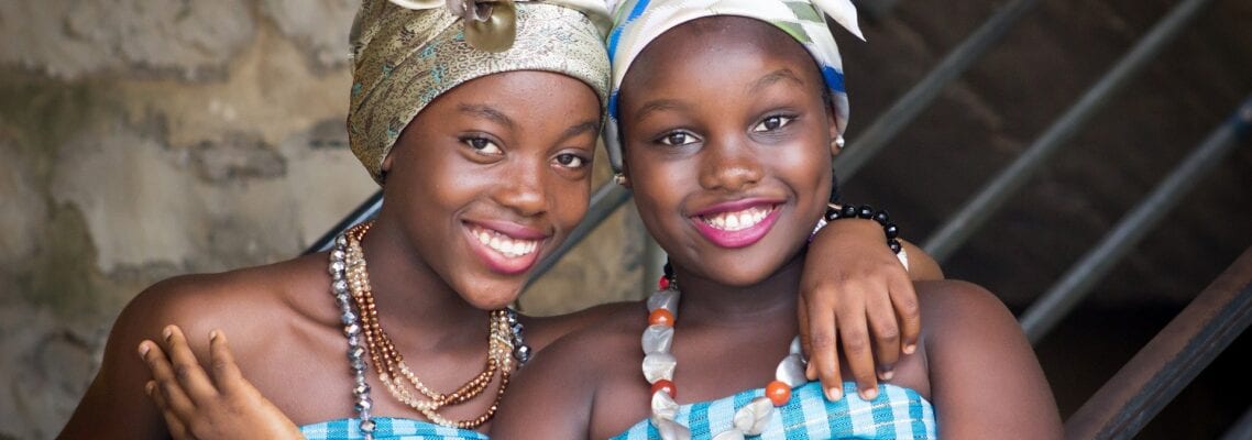 Two young women in blue dresses and head scarves.