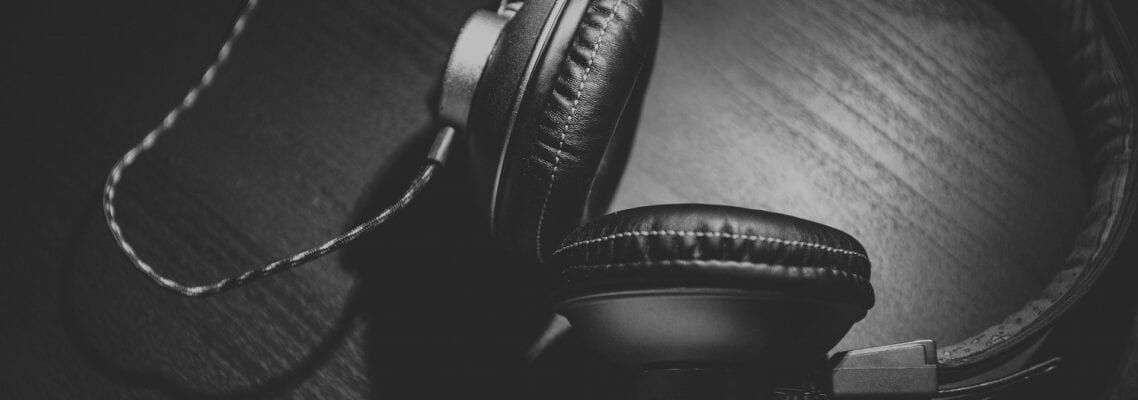 A pair of headphones sitting on top of a wooden table.