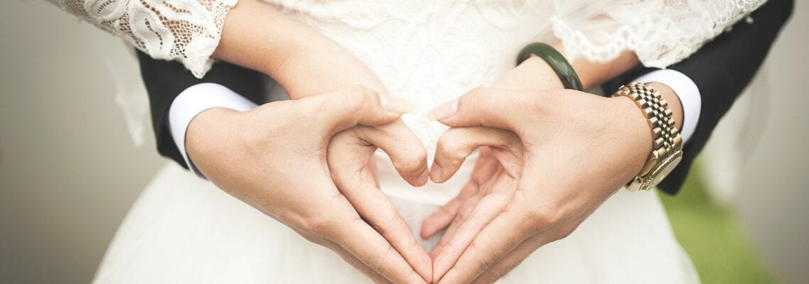 A close up of two hands making heart shapes