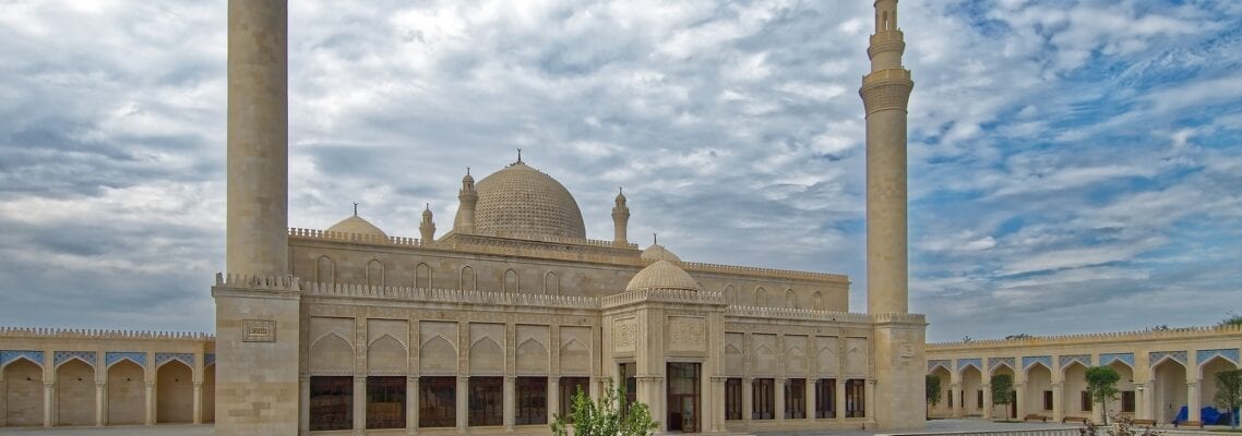 A large building with two domed towers and a courtyard.