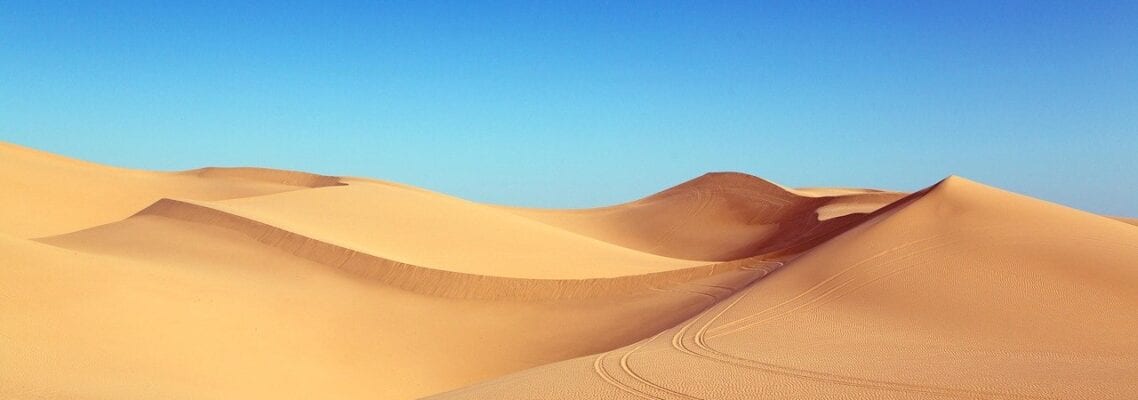 A desert with sand dunes and blue sky