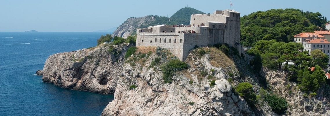 A castle on top of a rock in the middle of water.