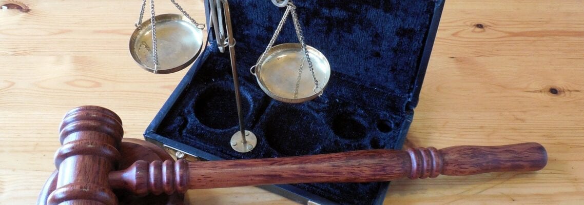 A wooden gavel and scale in an open case.