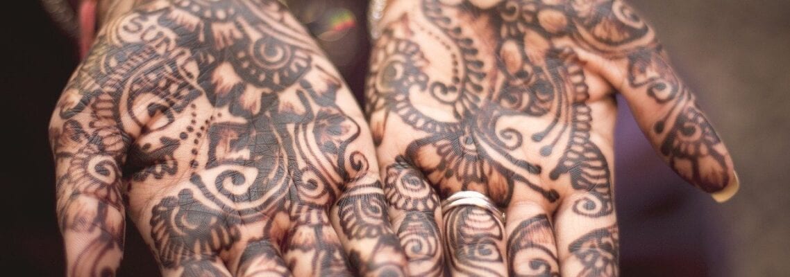 A close up of the hands with henna tattoos