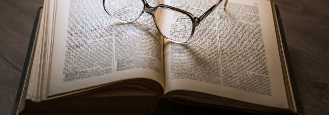 A book with glasses on top of it.