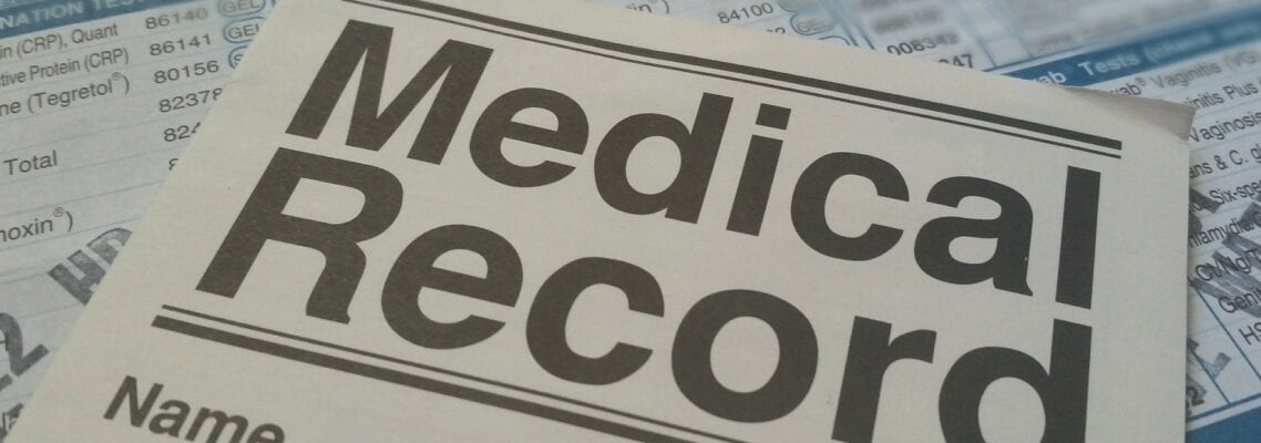 A medical record is shown on top of the papers.