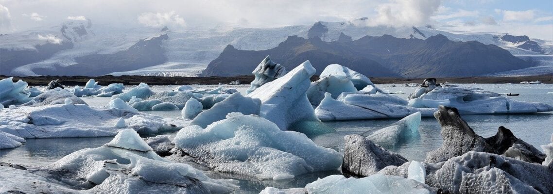 A group of ice bergs floating in the water.