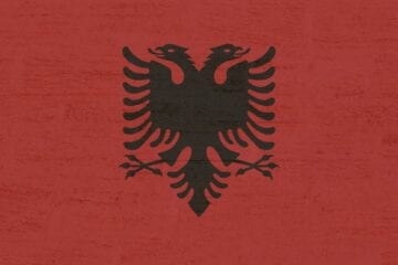 A red background with an image of the albanian flag.