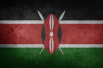 A flag of kenya with two spears on it.