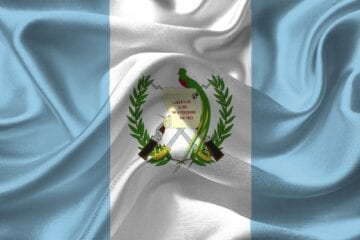 A flag of guatemala with the coat of arms on it.