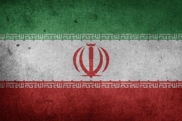 A flag of iran with the symbol for the country 's national emblem.