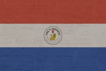 A red white and blue flag with the seal of paraguay on it.