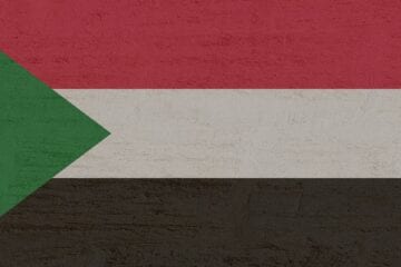 A flag of sudan with the colors red, white and black.