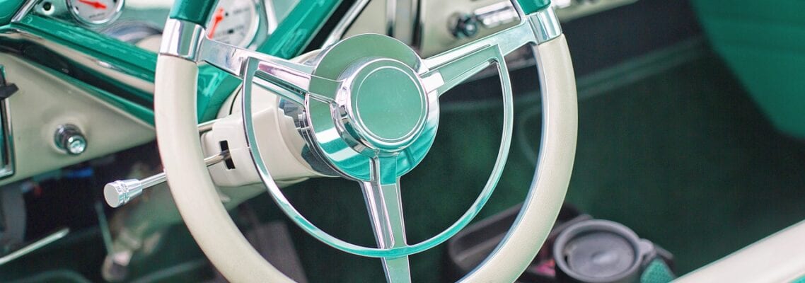 A close up of the steering wheel on an old car