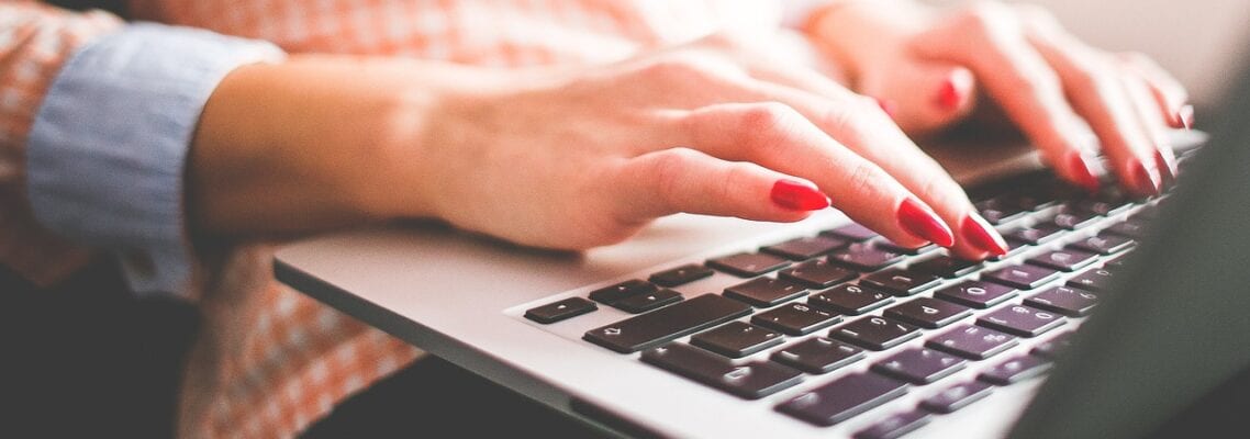 A person typing on a laptop computer.