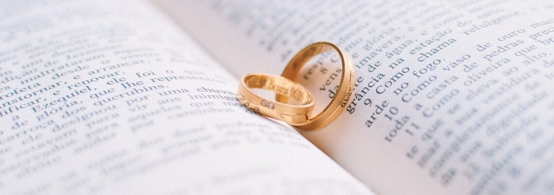 A close up of two rings on top of an open book