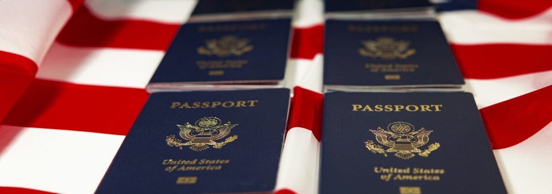 A close up of several passports on top of an american flag.