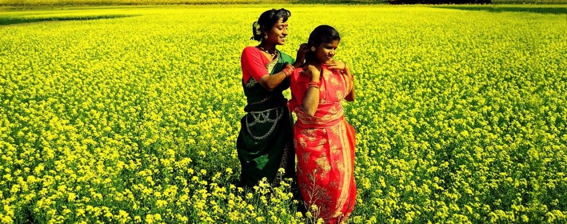 Two women in a field of yellow flowers